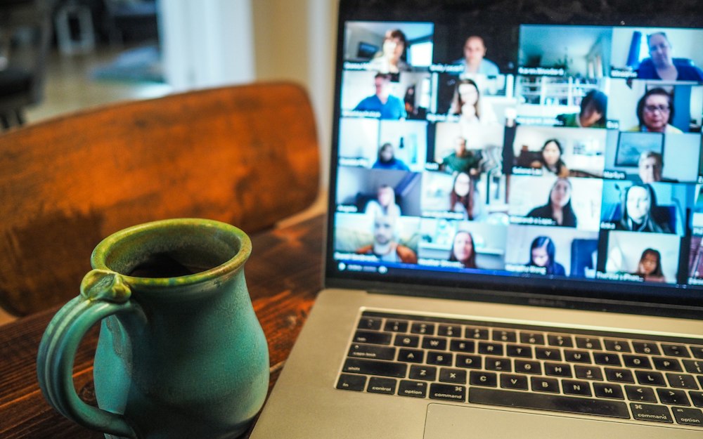 A laptop showing a video call with many participants